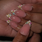 Extensiones de uñas decorativas con punta francesa y detalles de gemas