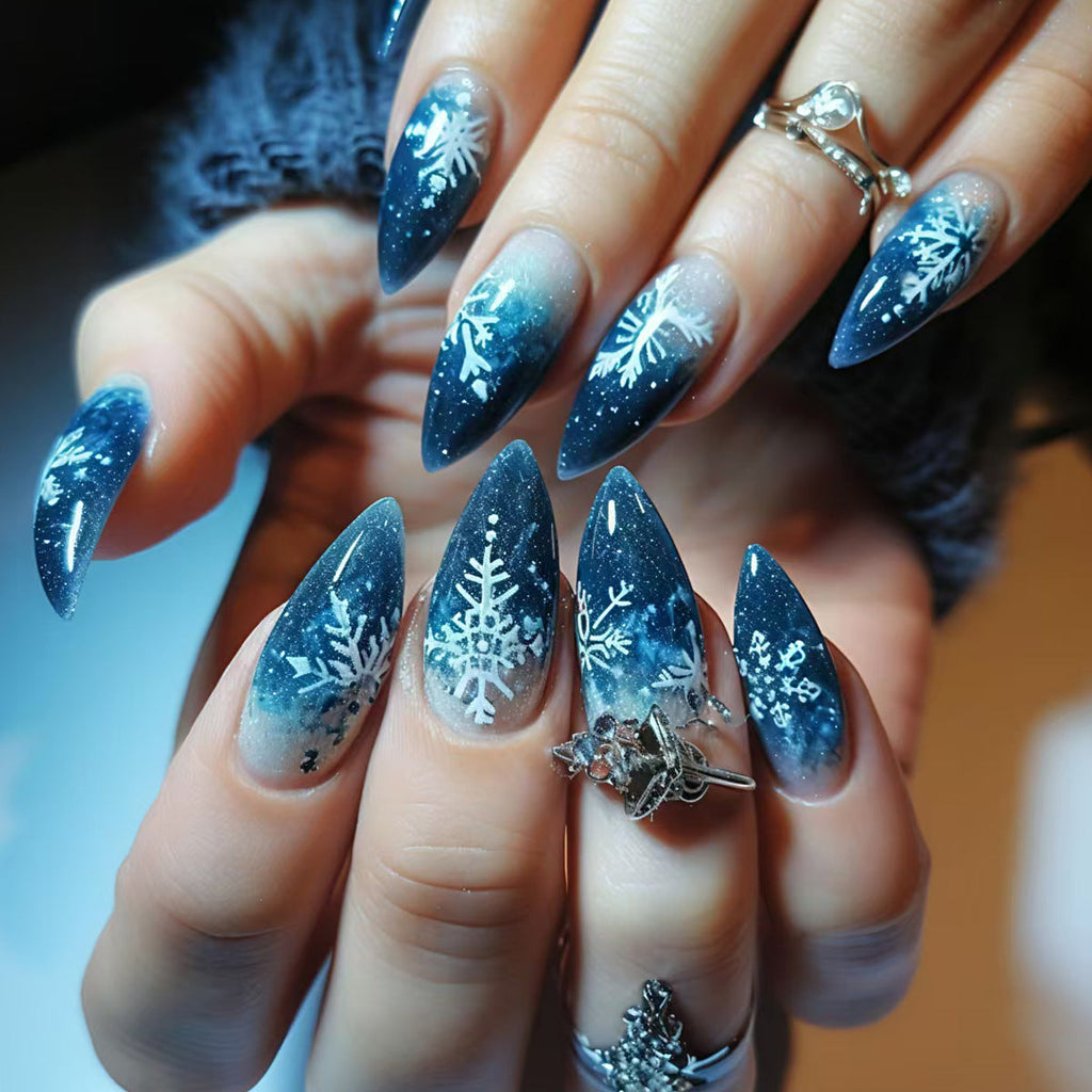 Diseño de uñas stiletto con estampado de copos de nieve